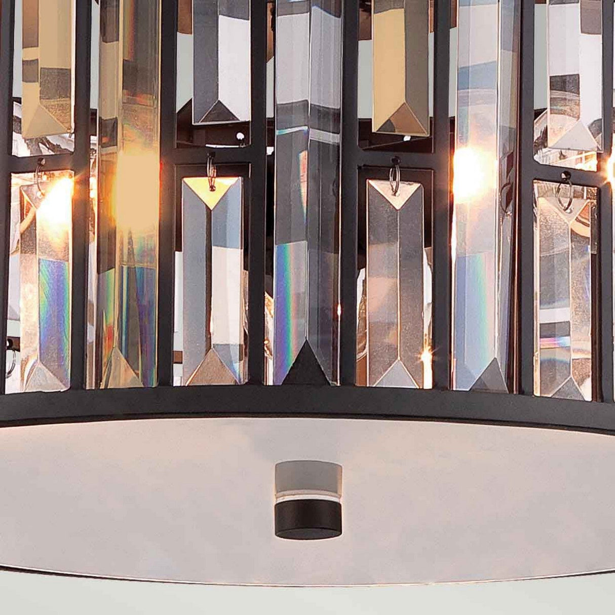 A close-up of the Gemma 3 Light Flush in Vintage Bronze showcases its rectangular, vertical crystal prisms reflecting light beautifully. Several small bulbs emit a warm glow, creating reflections and colorful light patterns that are perfect for a flush mount light setting.