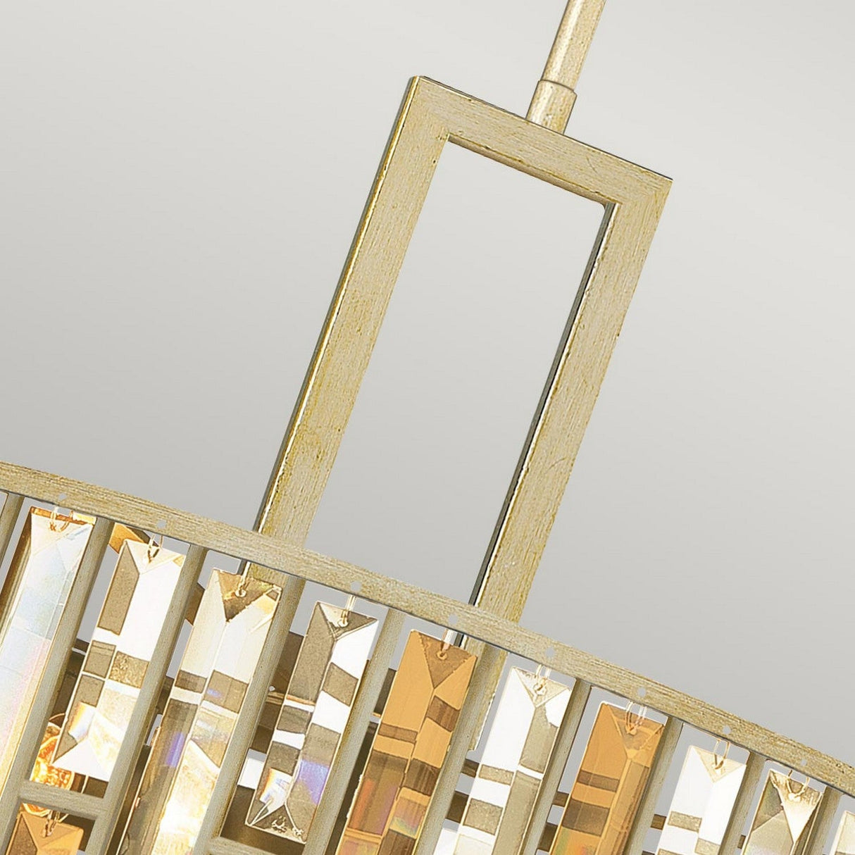 Close-up of the Gemma 3 Light Chandelier - Gold, featuring a rectangular gold-tone frame embellished with crystal panels. The prism-like crystals expertly reflect light to produce a shimmering effect, complemented by the soft gray background that elevates the elegance of the design.