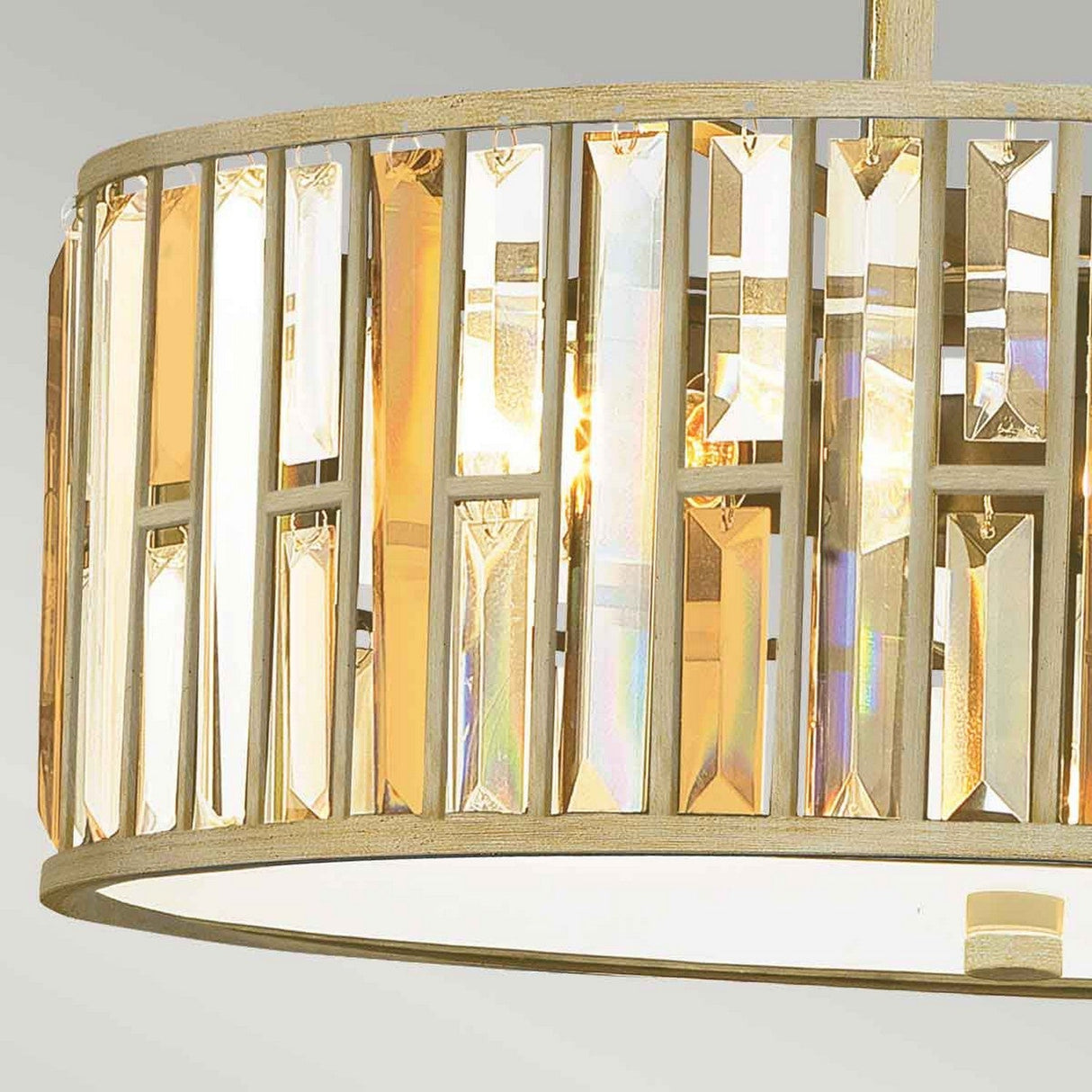 Introducing the Gemma 3 Light Chandelier - Gold: a close-up view reveals its circular frame adorned with vertical crystal prisms. The gold crystals beautifully reflect light, producing an elegant, shimmering effect, while the frame boasts a sophisticated metallic finish.