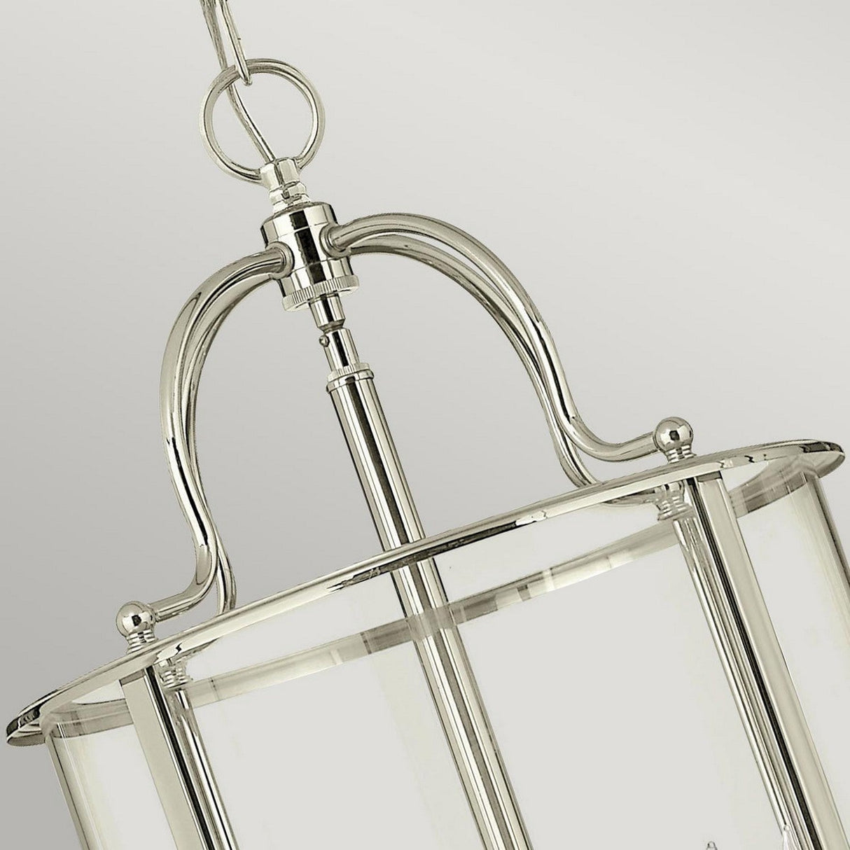 Close-up of the Gentry 6 Light Large Pendant - Polished Nickel with clear bent glass panels. The fixture features a curved metal design and hangs elegantly from a chain against a plain, light gray background.