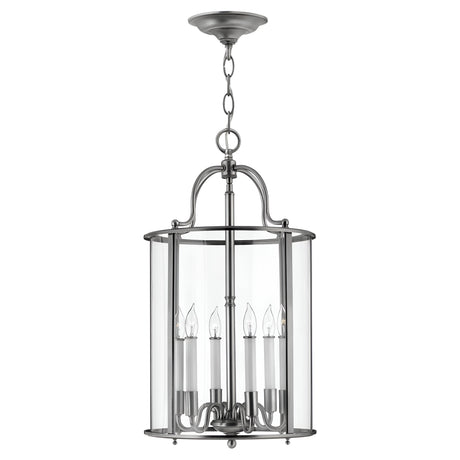 The Gentry 6 Light Large Pendant - Silver is a modern masterpiece, showcasing a cylindrical glass enclosure complemented by a brushed metal frame. It features six candle-style bulb holders inside, making it a stunning contemporary lighting fixture that hangs elegantly from a chain and circular ceiling mount.