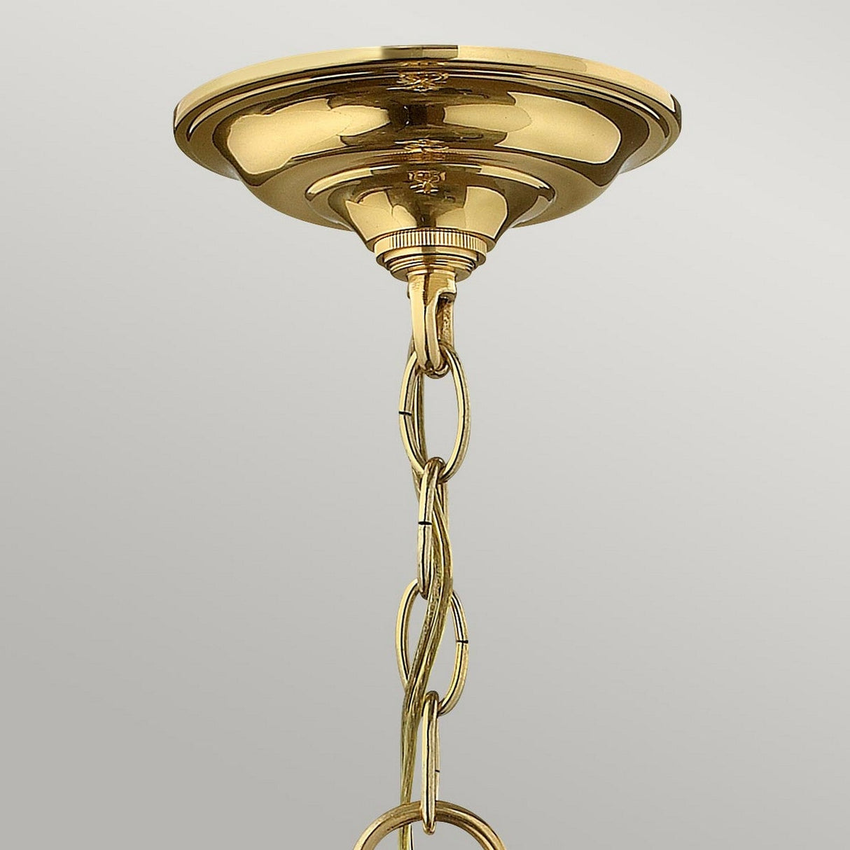 A detailed view of the Gentry 4 Light Medium Pendant in polished brass, featuring a decorative chain. This traditional design highlights clear bent glass panels, exuding elegance against a light gray backdrop.