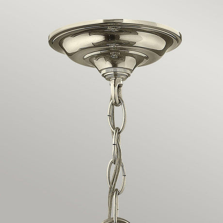 Close-up of the Gentry 4 Light Medium Pendant in polished nickel, featuring a round base and chain extending downward. The fixture showcases a shiny finish and simple, elegant design against a softly lit gray background.