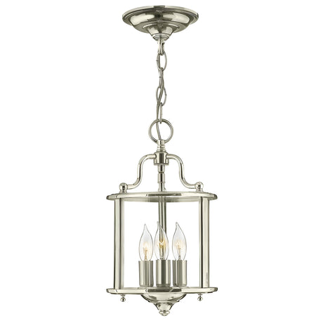 The Gentry 3 Light Small Pendant in polished nickel showcases a classic lantern design with three candle-shaped bulbs enclosed within clear bent glass, all suspended from a decorative chain.