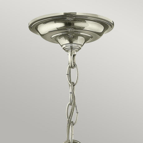 A close-up of the Gentry 3 Light Small Pendant in a polished nickel finish showcases its metallic ceiling mount. A decorative metal chain extends downward, designed for hanging the small pendant, against a light gray background.