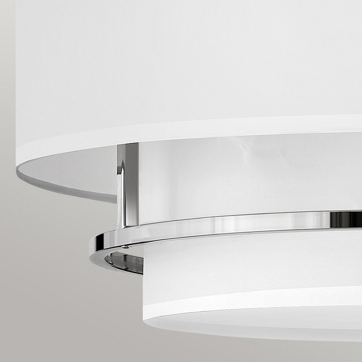 A close-up of the Graham 4 Light Duo-Mount Pendant/Semi-Flush in polished nickel is showcased against a light gray background. It features a modern design with a white cylindrical shade and layered elements that create a minimalist, elegant appearance. This fixture offers dual-mount capability for versatile installation options.