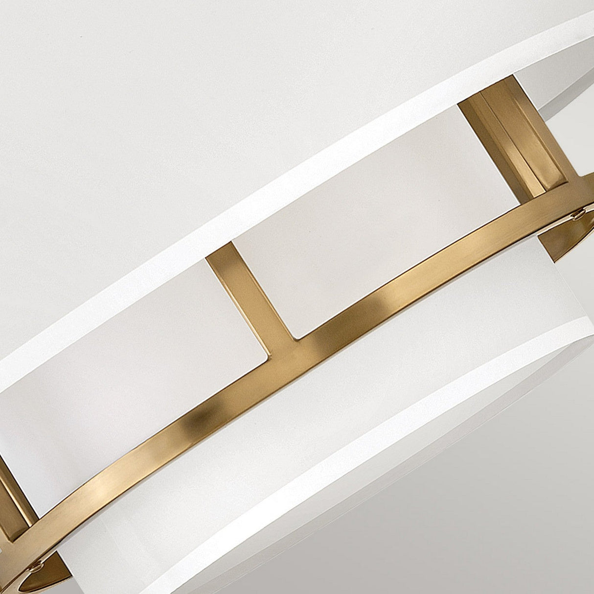 Close-up of the Graham 3 Light Duo-Mount Pendant/Semi-Flush, showcasing its modern design with a white circular shade and a sleek lacquered brass accent that crosses the middle horizontally for a contemporary look.