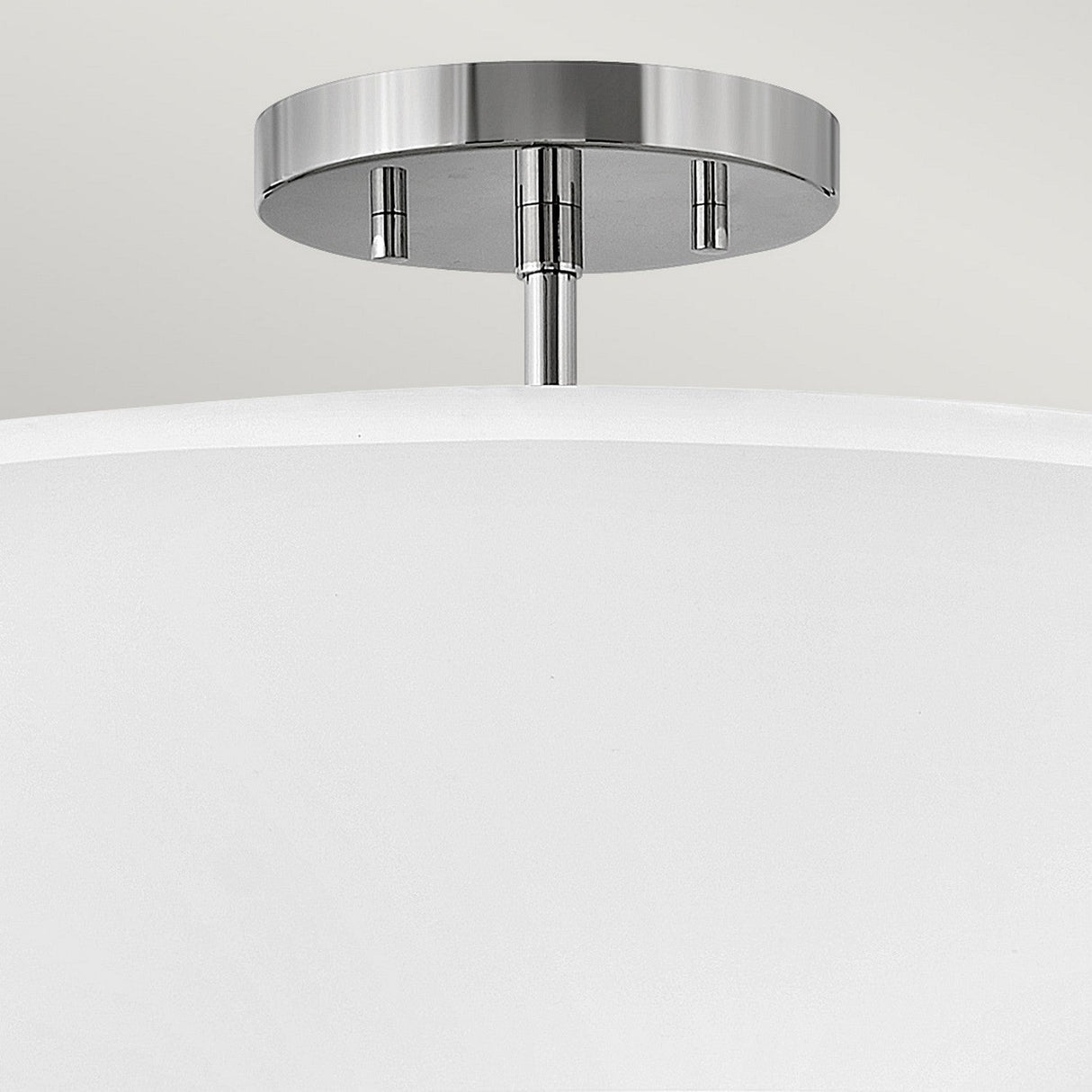 A close-up of the Graham 3 Light Duo-Mount Pendant/Semi-Flush featuring a polished nickel finish and a white shade. This fixture boasts a sleek, contemporary design, ideal for both home and office interiors.