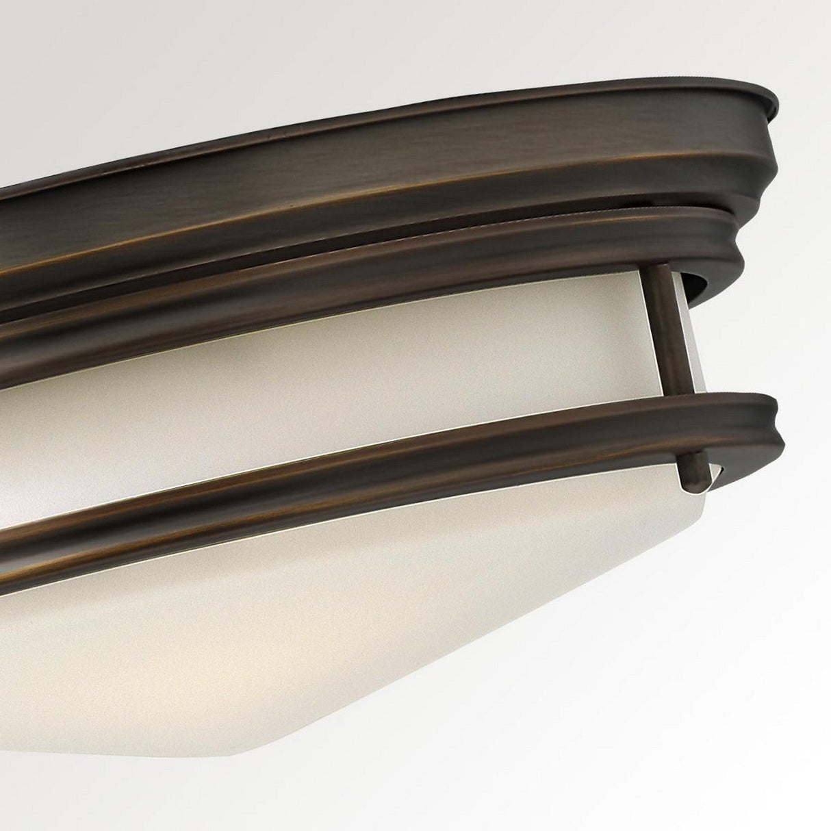 Close-up of the Hadley 3 Light Flush in bronze, showcasing its elegant curved lines and frosted glass diffuser for a sleek, contemporary aesthetic.