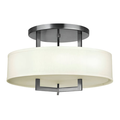 Introducing the Hampton 3 Light Semi Flush - Antique Nickel With Ivory Shade, featuring a modern round linen drum shade and a sleek metallic frame. The design includes dark metal accents with an Antique Nickel finish, offering clean lines and a timeless semi-flush mount perfect for any contemporary space.