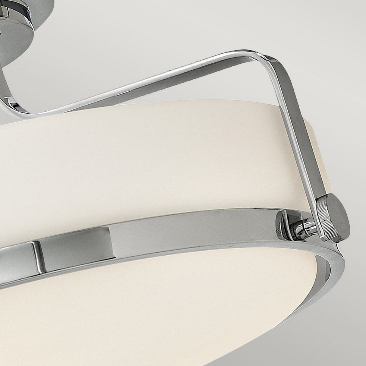 A close-up of the Harper 3 Light Medium Semi Flush showcases its modern design, featuring a polished chrome metal frame supporting an oval-shaped opal etched glass shade. The minimalist aesthetic with clean lines is highlighted against a plain gray background.