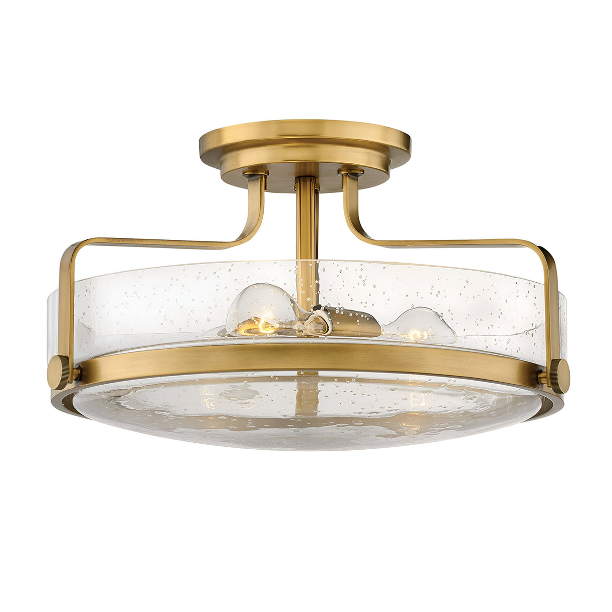 The Harper 3 Light Medium Semi Flush features a minimalist design with a heritage brass frame and clear seeded glass shade, showcasing a bubbled texture. It blends contemporary and classic styles, suspended as a semi-flush mount with a round ceiling attachment.