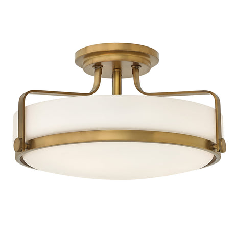 The Harper 3 Light Medium Semi Flush features a modern design with a round, opal-etched glass shade and is finished in heritage brass.