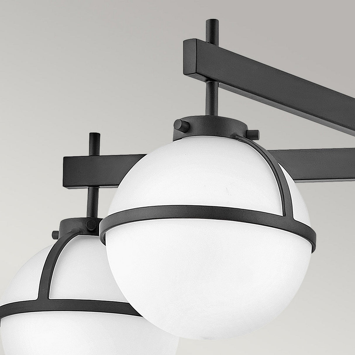 Close-up of the Hollis 5 Light Semi Flush fixture in black with opal etched glass shades, featuring a modern spherical pendant design and suspended from a rectangular fixture against a light gray background.