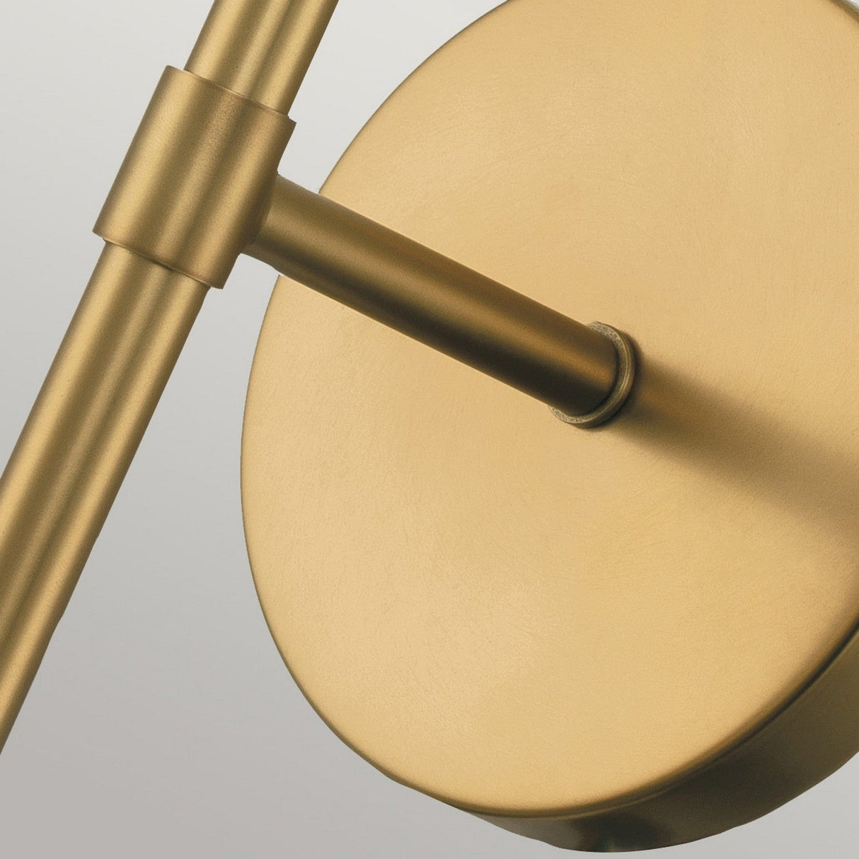 Introducing the Hollis 1 Light Wall Light in Heritage Brass with Clear Glass—a modern fixture that exudes Art Deco charm. It features a round backplate and a cylindrical arm with a sleek matte finish, beautifully contrasting against a light gray backdrop. This piece is the perfect touch of elegance for any space.