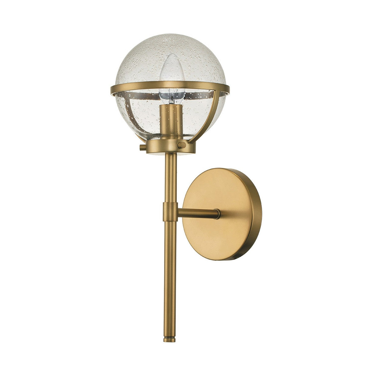The Hollis 1 Light Wall Light - Heritage Brass With Clear Glass is a modern Art Deco sconce featuring a sleek vertical design. It mounts to the wall with a circular plate and includes a round, clear glass shade that encloses a single bulb, seamlessly merging timeless elegance with contemporary style.