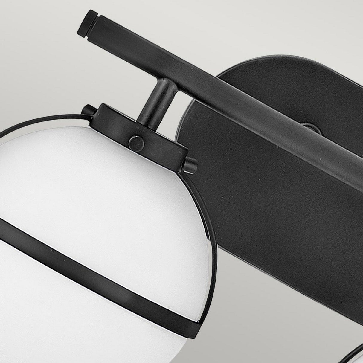 Close-up of the Hollis 2 Light Wall Light in a black finish, featuring an opal glass shade enclosed in a sleek black metal frame and mounted on a rectangular base. The design blends contemporary style with Art Deco elegance, making it ideal for modern interior decor.