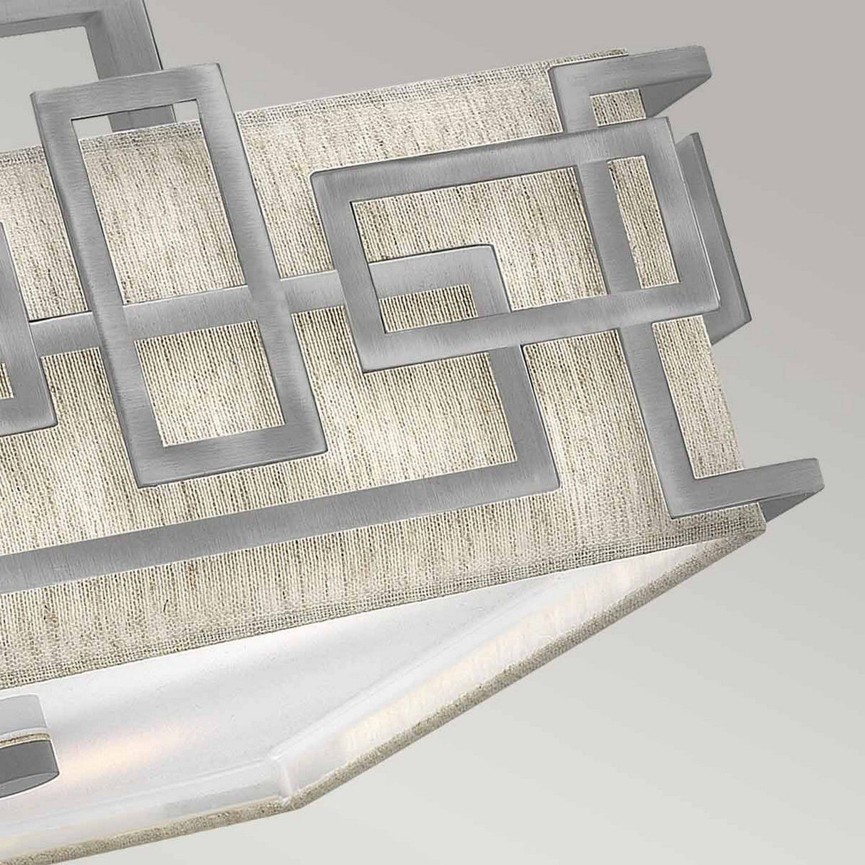 Close-up of the Lanza 3 Light Semi Flush in antique nickel, featuring a striking geometric design. The intersecting square and rectangular shapes in brushed metal are beautifully contrasted against a soft, textured fabric background.