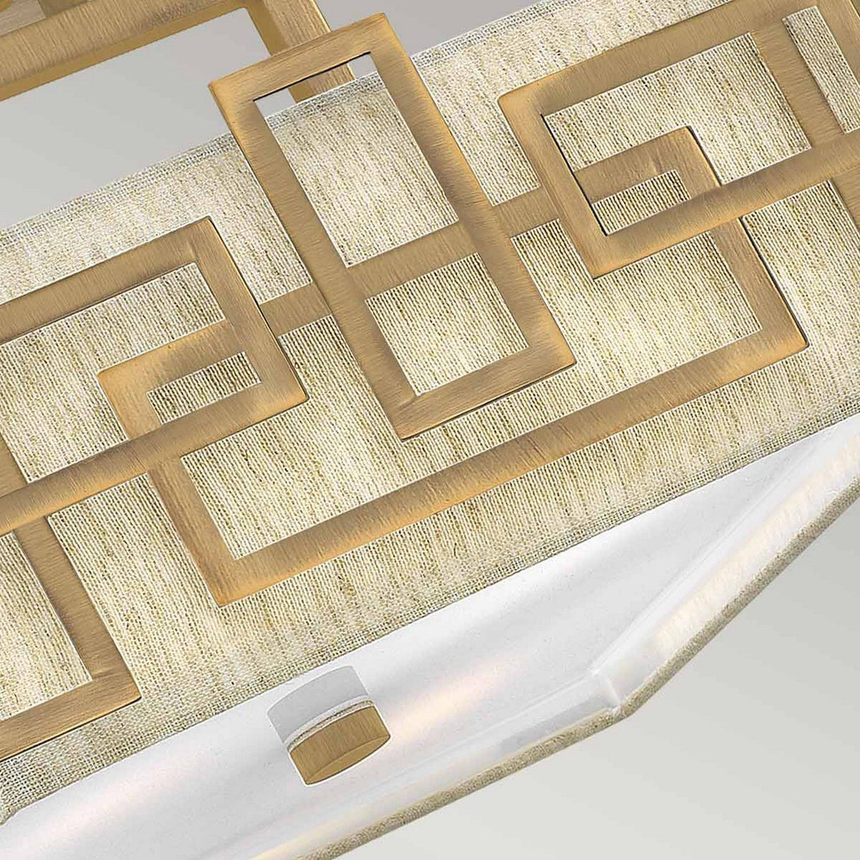 Close-up of the Lanza 3 Light Semi Flush - Brushed Bronze, featuring an intricate geometric form on a textured beige background. The design boasts a rectangular shape with a frosted glass panel beneath the pattern.