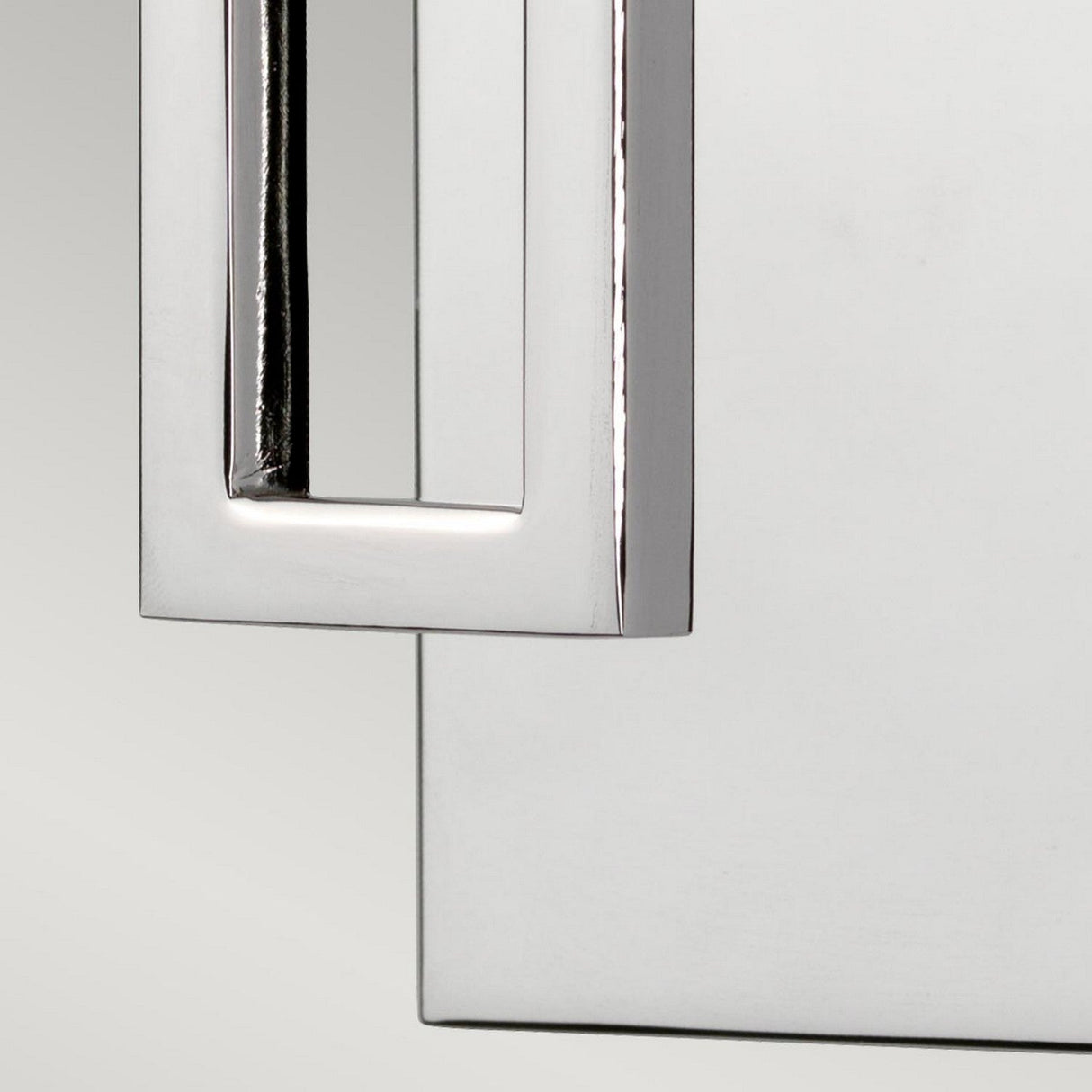 Close-up of the Lanza 1 Light Wall Light in polished chrome, featuring a modern and sleek metallic handle attached to a rectangular surface with a reflective and polished finish. The background is a soft gradient gray, accentuating its minimalist design and contemporary craftsmanship.