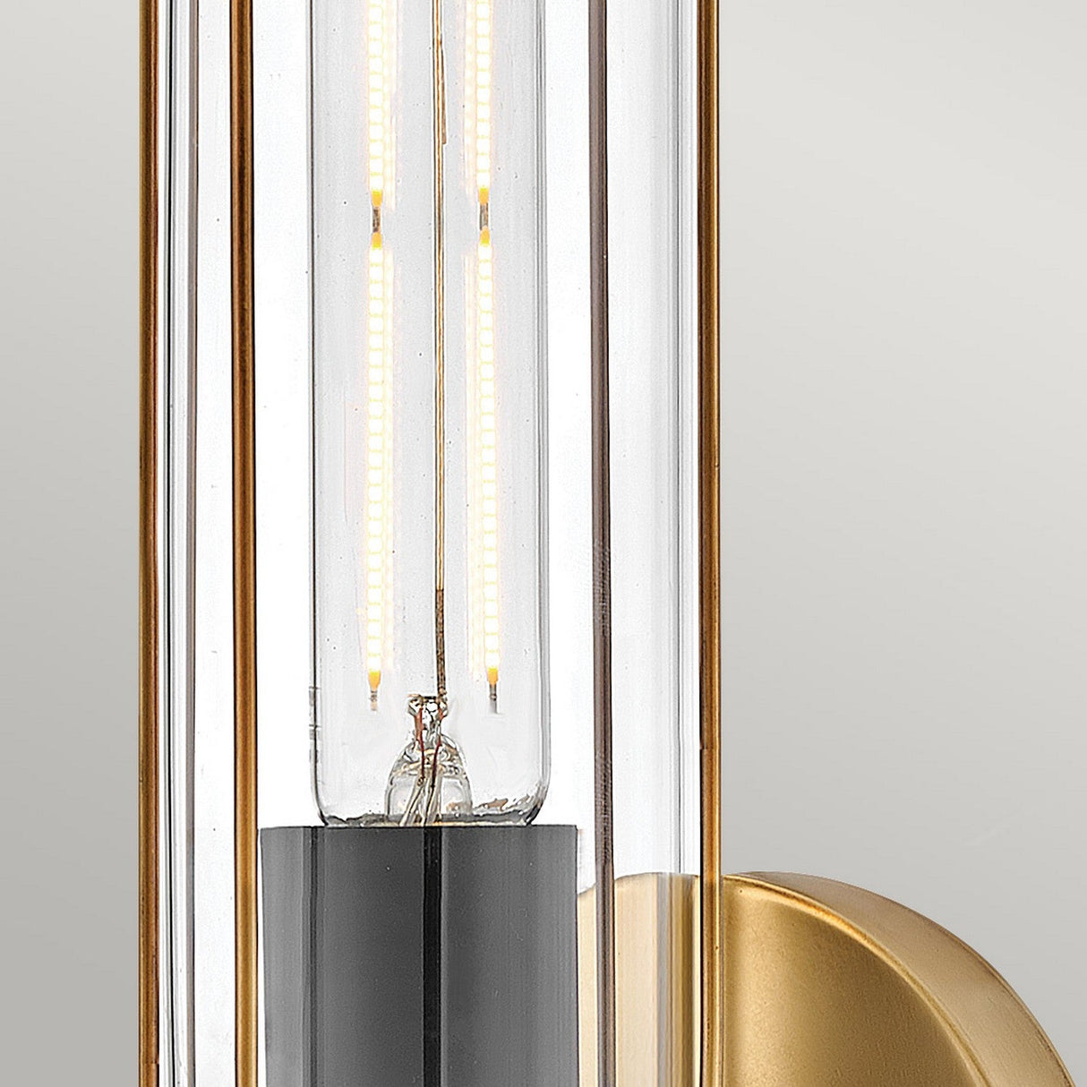 Close-up of the Masthead 1 Light Wall Light - Heritage Brass & Black, featuring a glass bulb with a visible filament. The design exudes nautical charm, with its heritage brass and black base set against a neutral background.