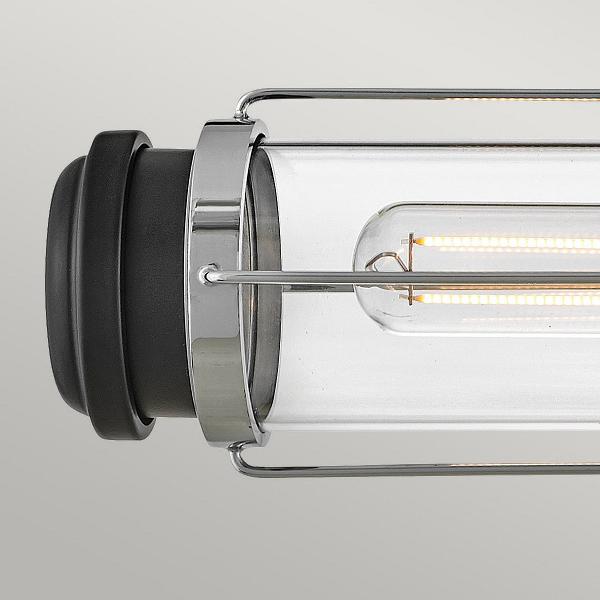 Discover the Masthead 2 Light Wall Light - Polished Chrome & Black, a contemporary fixture that combines industrial flair with nautical charm. It boasts a clear cylindrical glass casing paired with polished chrome metallic accents and black end caps set against a simple backdrop.