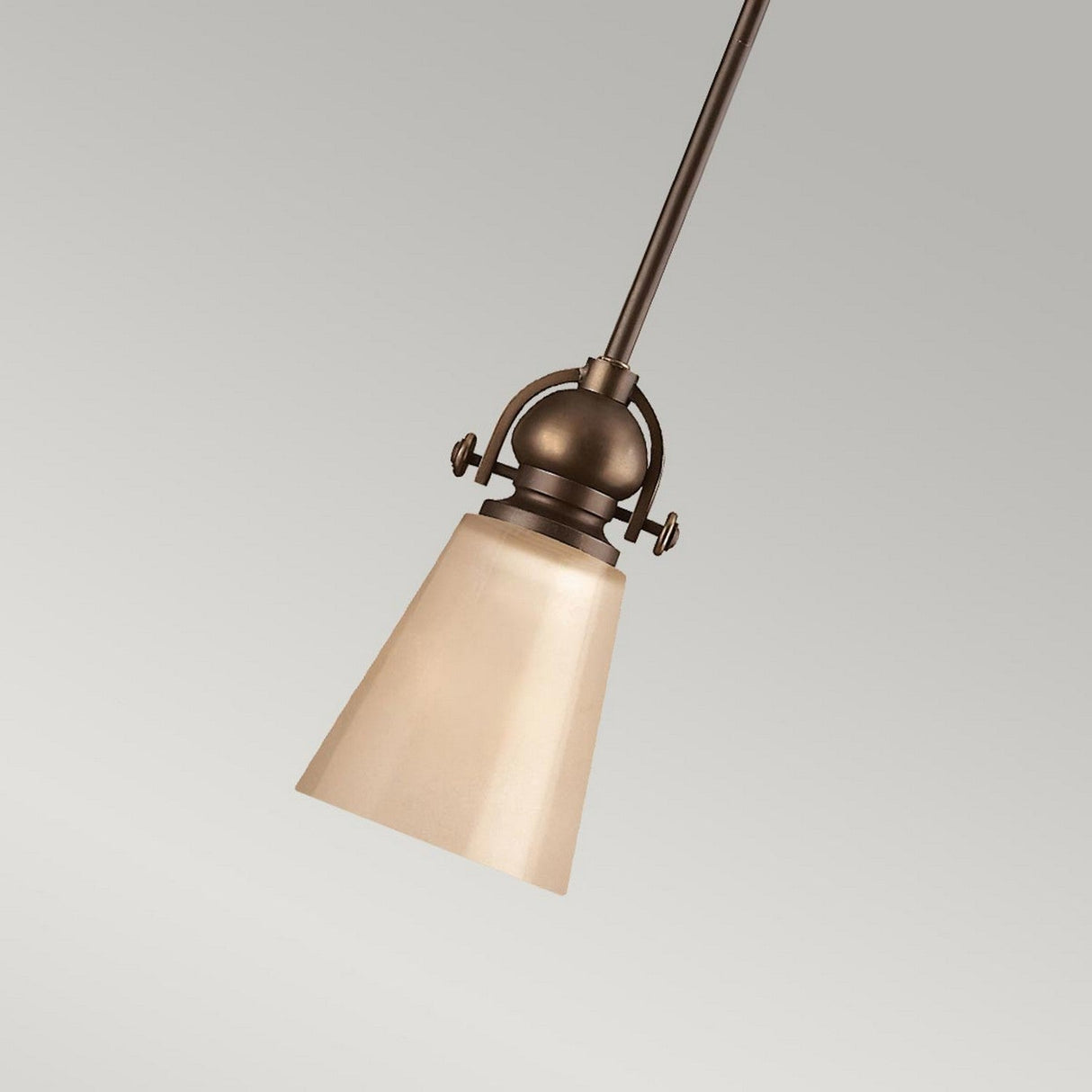 The Mayflower-1 1 Light Mini Pendant in Olde Bronze boasts a metal fixture paired with an etched amber glass conical shade, offering a stunning contrast against its plain gray background.