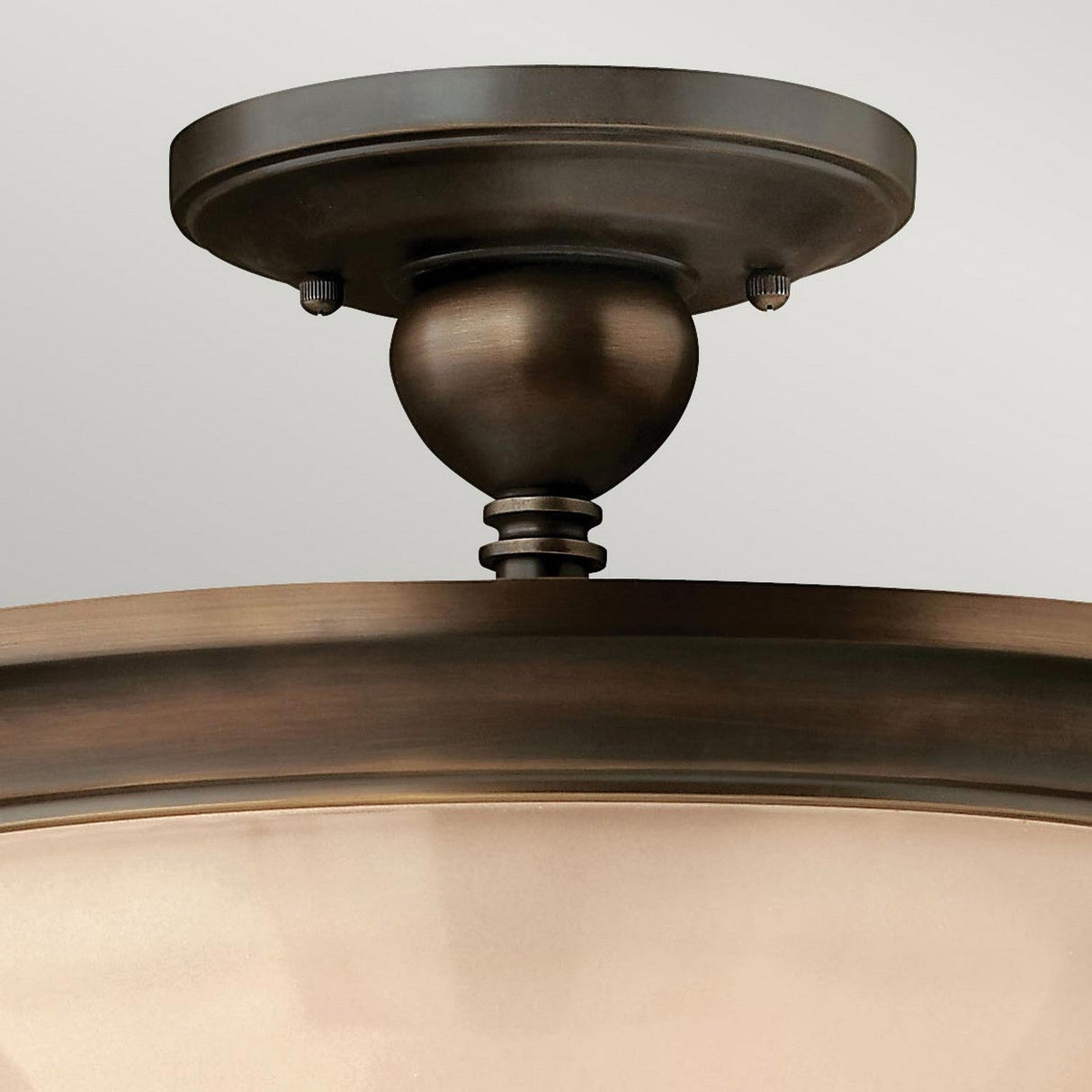 Close-up of the Mayflower 3 Light Semi Flush - Bronze with frosted, etched amber glass shades. The fixture showcases a classic design with a smooth finish, mounted on a flat circular base against a light gray background.
