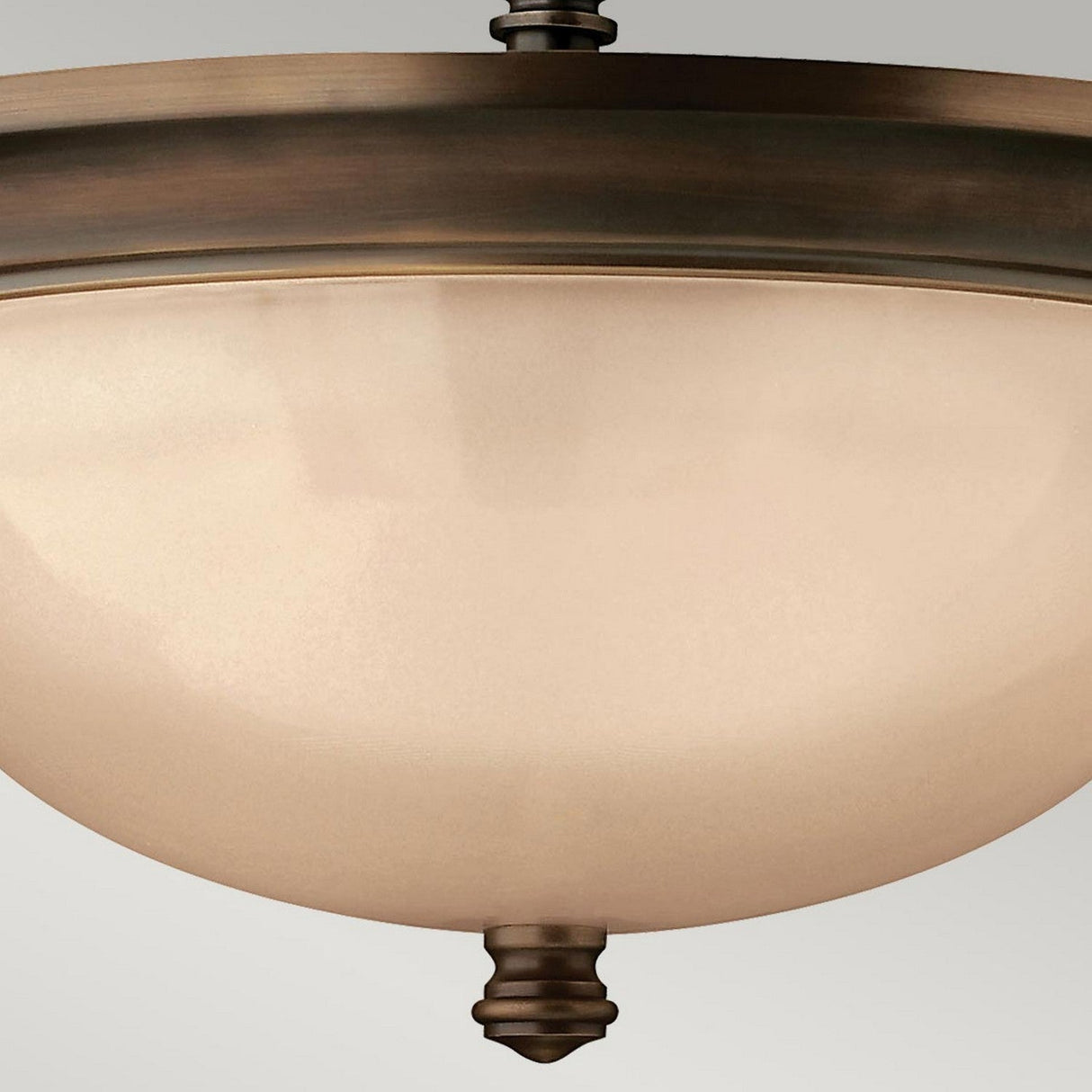 A close-up view of the Mayflower 3 Light Semi Flush - Bronze fixture featuring a frosted glass dome and a classic design with decorative finials and etched amber glass shades, set against a neutral background.