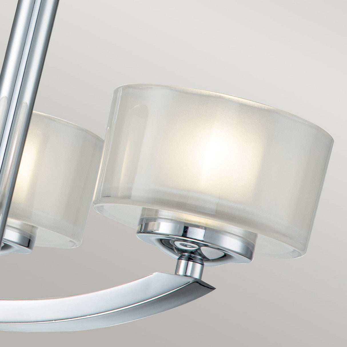 Featuring the Meridian 3 Light Semi Flush - Polished Chrome, this close-up showcases a sleek light fixture with a translucent cylindrical shade and polished chrome accents, exuding a soft, warm glow. Its semi-flush design introduces a modern flair while promoting energy efficiency in the space.