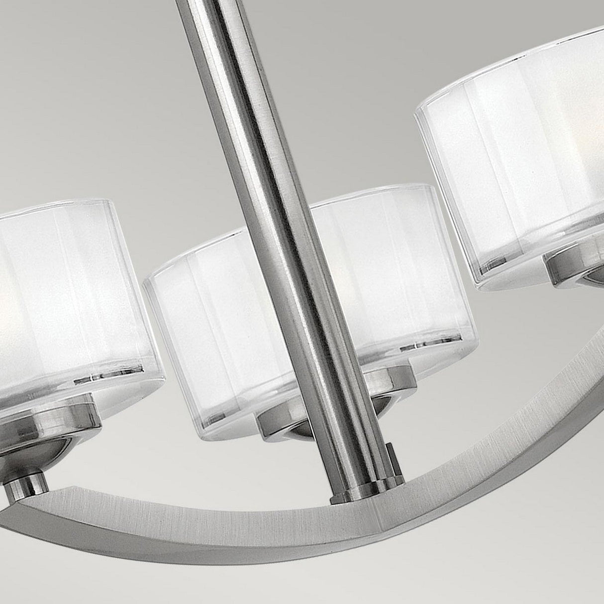 The Meridian 3 Light Semi Flush in Brushed Nickel is a modern ceiling light fixture that incorporates energy-efficient technology and features three cylindrical, frosted glass shades on a sleek, curved metal arm, all set against a light gray background.