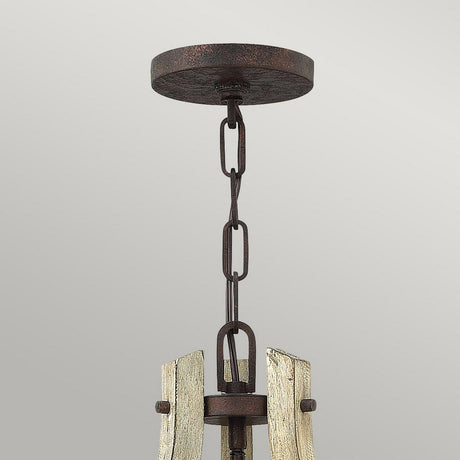 A close-up view of the Middlefield 3 Light Chandelier - Iron Rust showcases its rustic chic design, with a metal chain hanging from a round ceiling mount. The iron rust finish and distressed wood accents are partially visible, enhancing its vintage style.