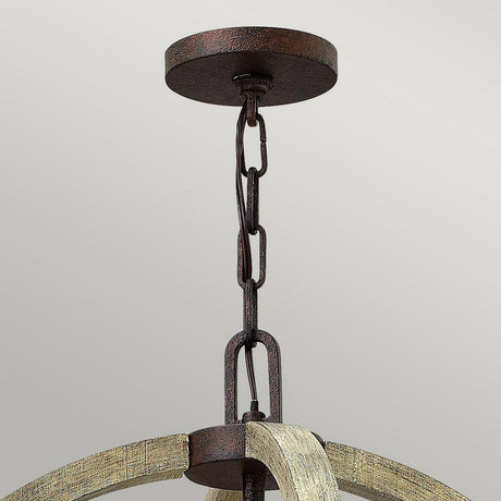 Here's a revised version of the sentence using the provided product data:
Featuring a close-up of the Middlefield 4 Light Chandelier - Iron Rust, this image highlights its round ceiling mount and chain. The fixture exudes rustic elegance with its iron rust tone and an arched distressed wood frame below, set against a plain off-white wall backdrop.