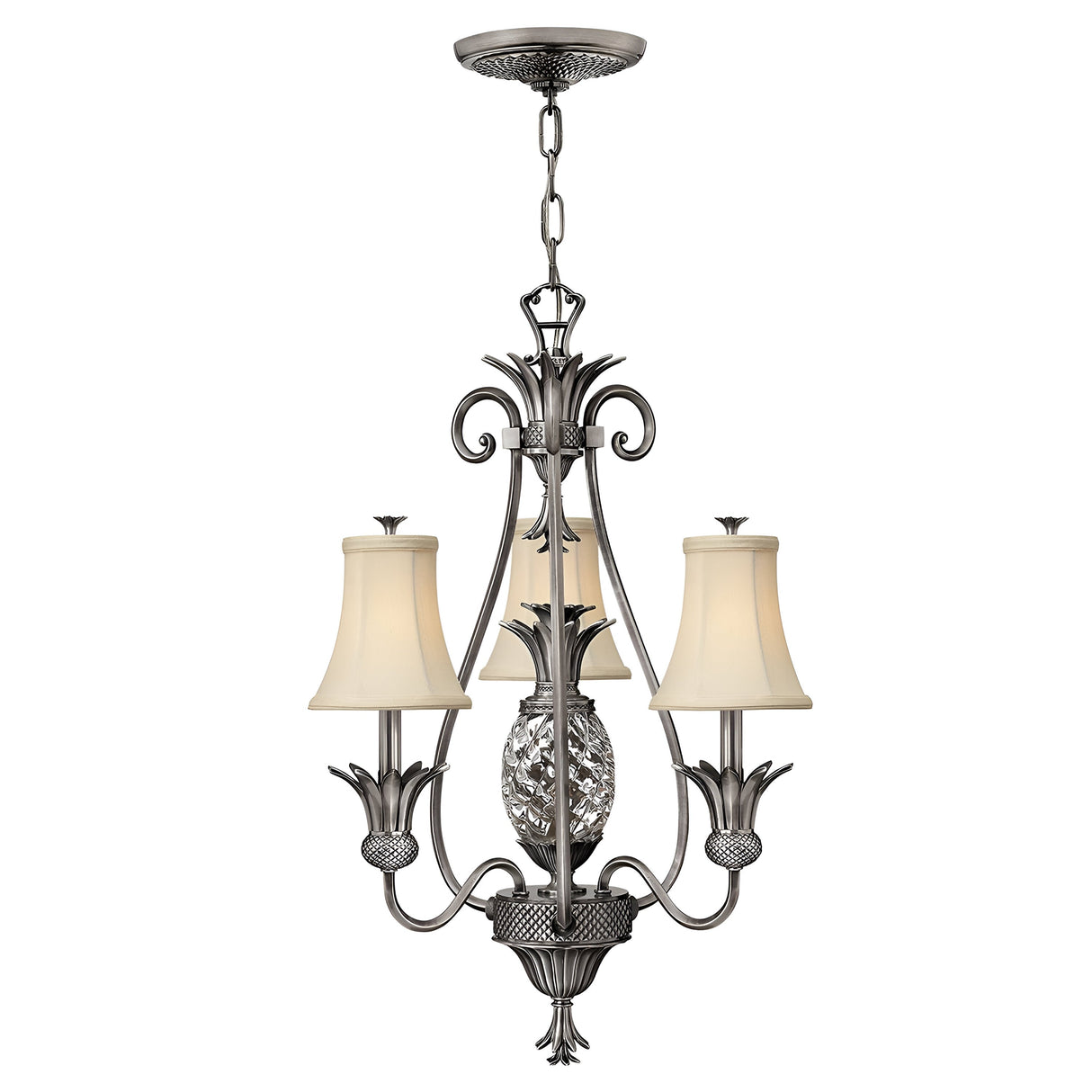 The Plantation 3 Light Chandelier - Polished Antique Nickel features an exquisite polished antique nickel finish, complemented by three white lampshades and graceful scrolling details. It is enhanced with a crystal element in the center, adding sophistication, while clear optic glass elevates its radiant charm.