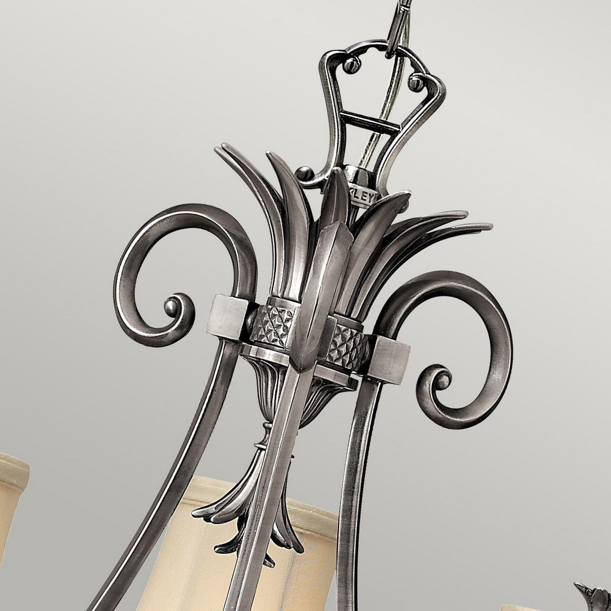 Close-up of the Plantation 3 Light Chandelier – Polished Antique Nickel, showcasing its intricate scrollwork and three frosted glass light shades against a neutral background.