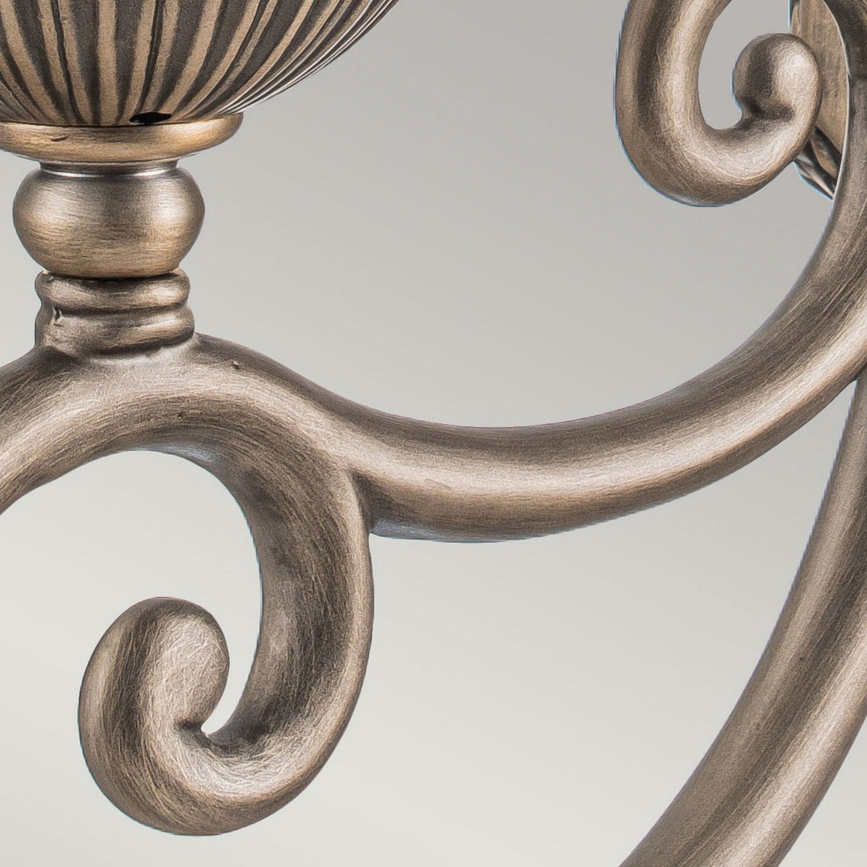 Close-up of the Plantation Outdoor 1 Light Medium Wall Lantern in a burnished bronze finish, featuring ornate curved scrollwork and intricate detailing. The elegant craftsmanship stands out against a neutral background, with the addition of pineapple optic glass enhancing its timeless appeal.