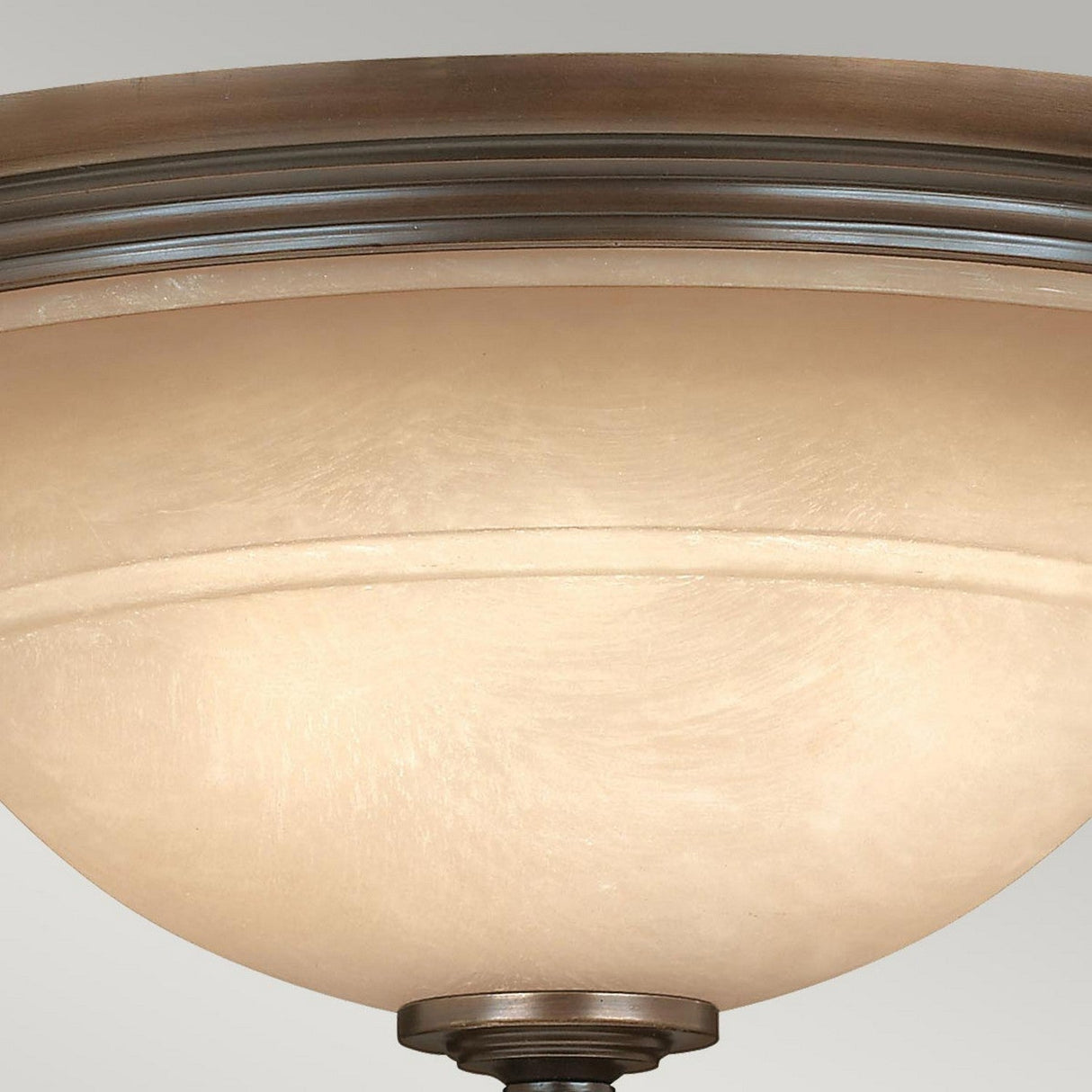 The Plymouth 3 Wall Light in Bronze showcases a close-up of its frosted glass dome, which emits a soft, warm glow. Its design is simple and elegant, reminiscent of organza shades in the way it gently diffuses light.