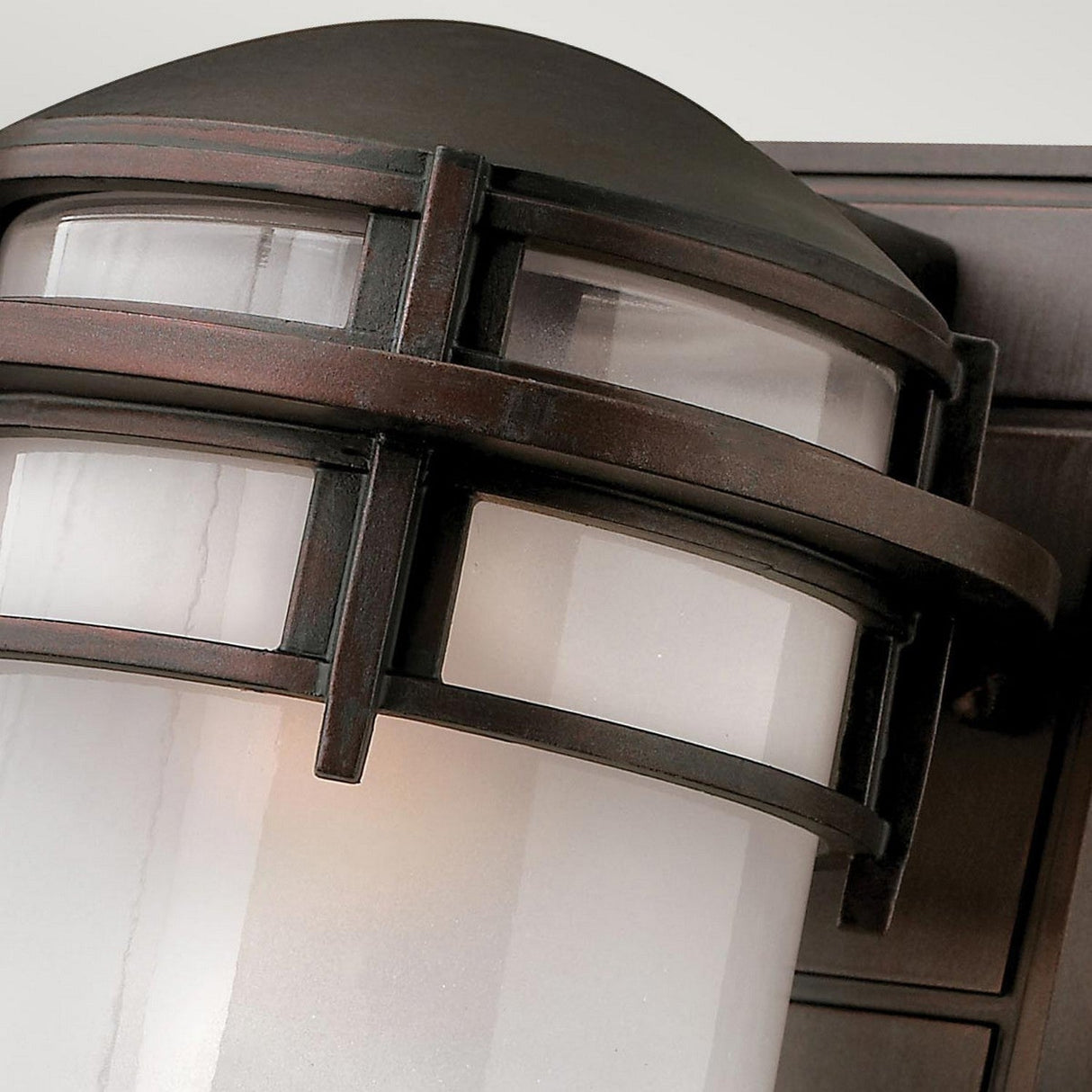 Close-up of the Reef Outdoor Small 1 Light Lantern in bronze, featuring frosted glass panels and a metal frame, ideal for outdoor use. The design highlights a modern nautical style with a curved metal top and horizontal bands, along with an IP44 rating for enhanced durability.