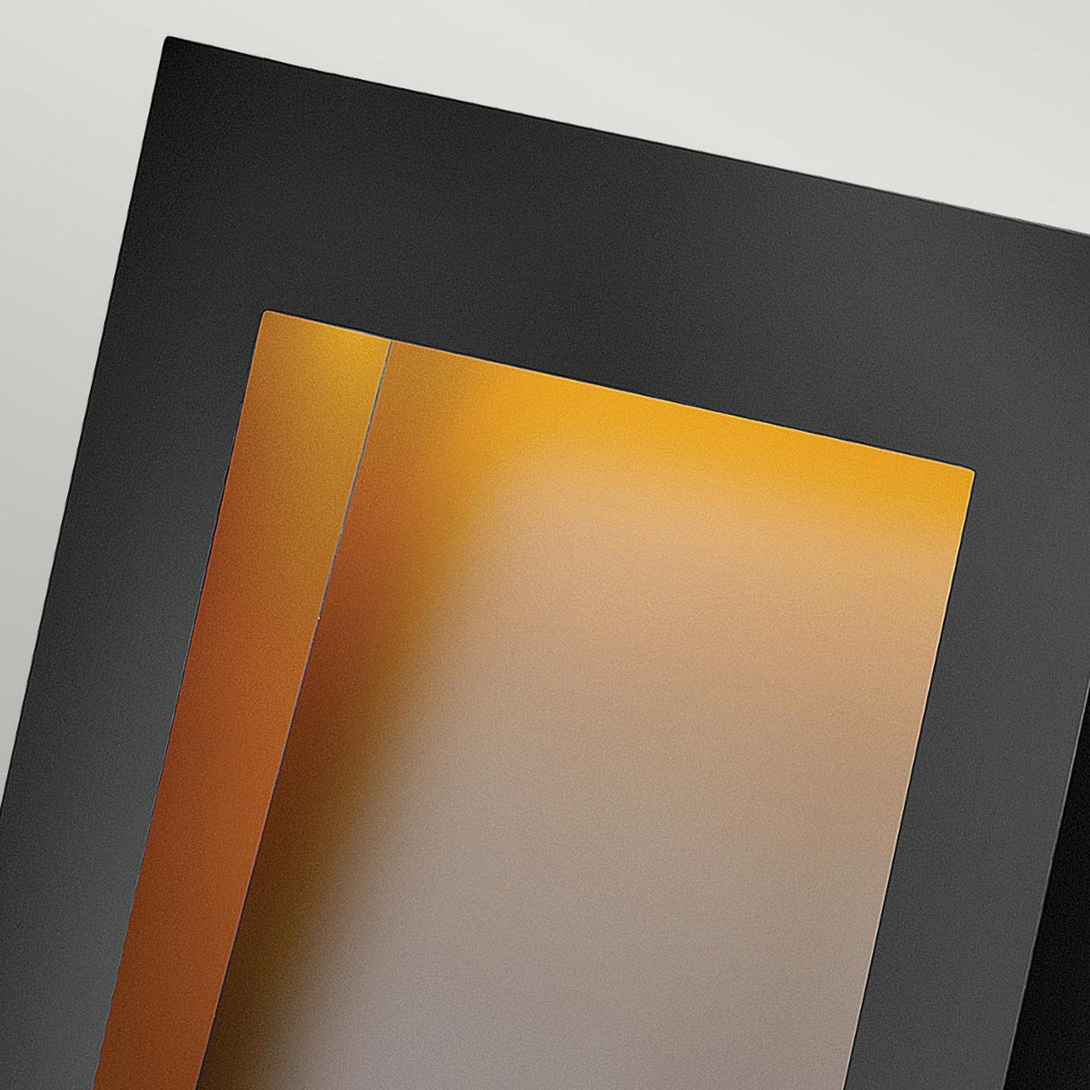 The image abstractly showcases overlapping rectangular shapes in black, gray, and orange. The orange portion emanates a warm, gradient effect similar to the modern aesthetics of the Taper Outdoor LED Large Wall Lantern - Black. This composition is minimalistic and geometric, capturing an angled perspective that echoes contemporary outdoor lighting design.