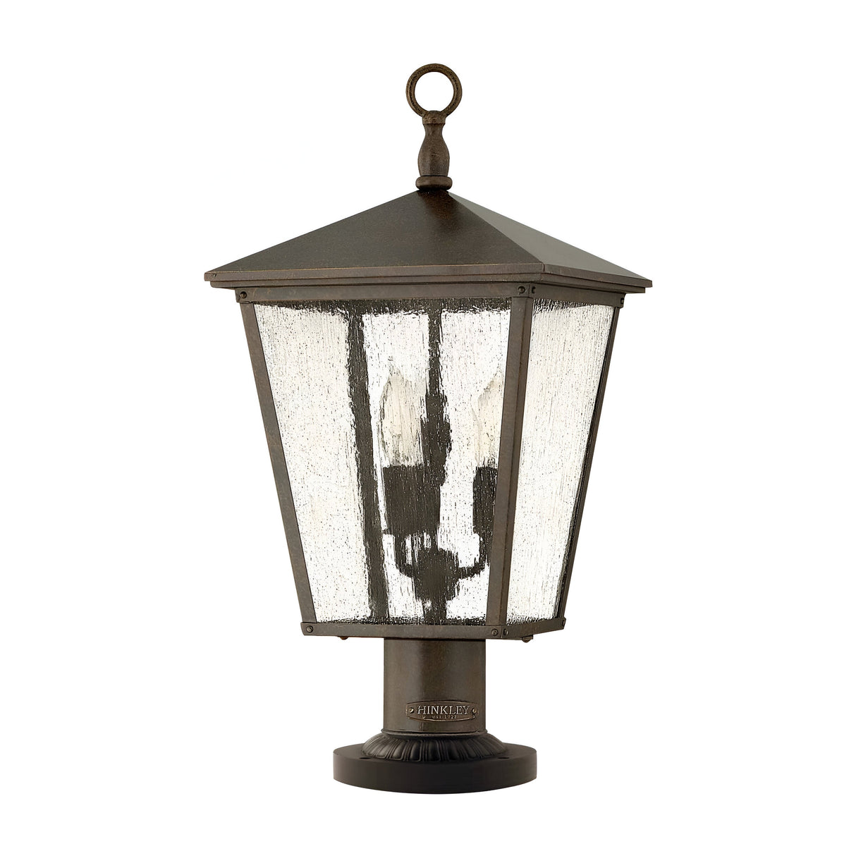The Trellis Outdoor 3 Light Large Pedestal - Bronze features a traditional design with a square frame and translucent glass panels. It includes a pointed metal top with a circular loop for hanging, providing excellent illumination for garden paths and making it an ideal outdoor lighting fixture.
