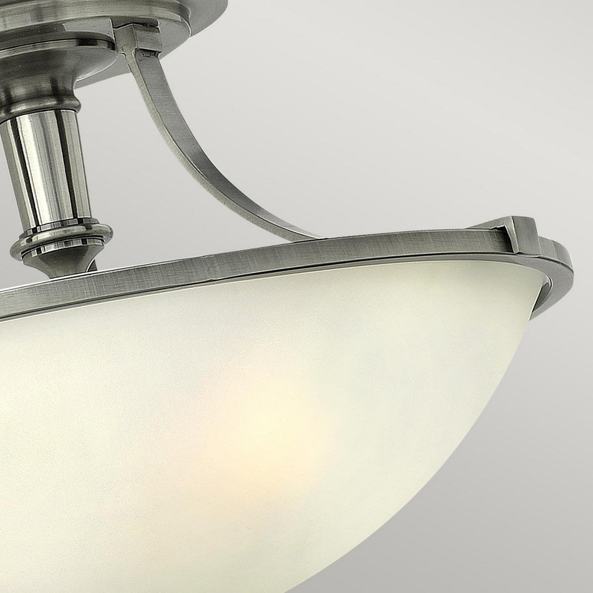 Close-up of the Truman 3 Light Semi Flush ceiling fixture with an Antique Nickel finish and etched opal glass, featuring a frosted, bowl-shaped shade that softly diffuses light against the neutral gray background.