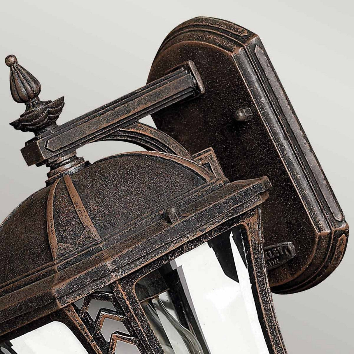 The Wabash Outdoor 1 Light Small Wall Lantern in bronze showcases vintage charm and enhances outdoor appeal. Its design includes a domed top, intricate details, and clear glass panes. Mounted to a rectangular backplate against a simple backdrop, this lantern adds an elegant touch to any exterior setting.