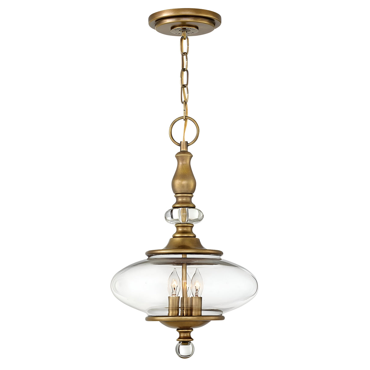 The Wexley 3 Light Chandelier - Heritage Brass exudes a vintage charm with its rich brass finish, elegantly suspended by a chain. This chandelier showcases a glass enclosure with three candle-style bulbs, capturing a transitional design that offers both sophistication and timeless appeal.
