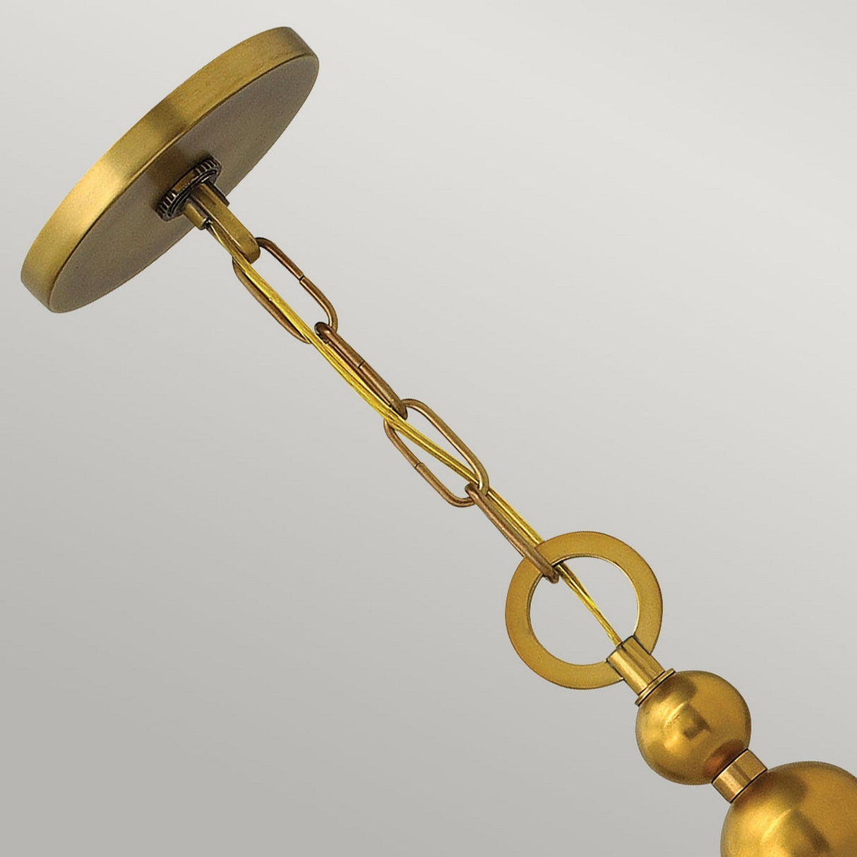 Close-up of the Zelda 3 Light Pendant in Vintage Brass, featuring a ceiling mount, linked chain, and decorative metal elements inspired by mid-century design against a plain background.