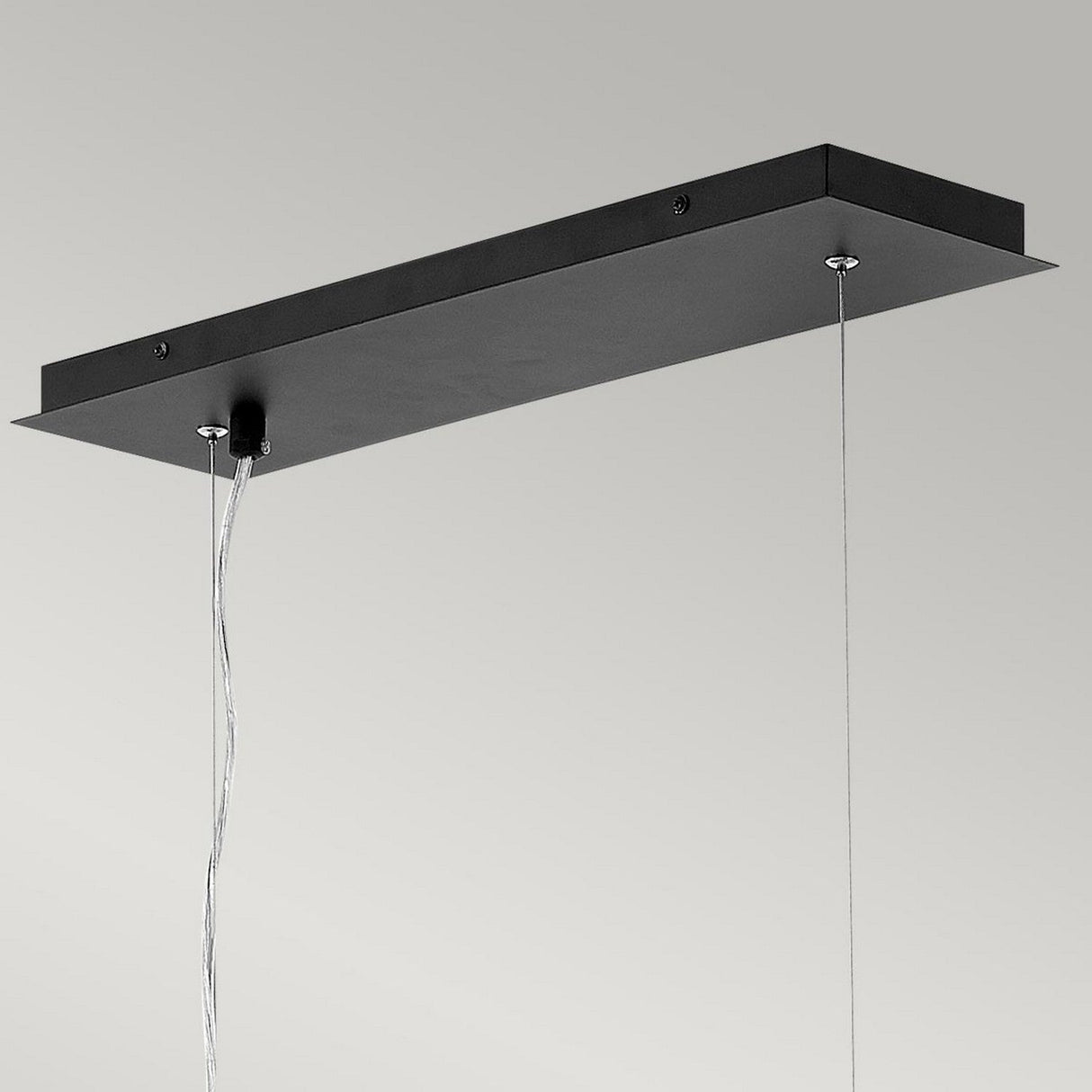 The Zuma 6 Light Linear Chandelier in Satin Black/Silver features a sleek rectangular design with two cords, providing ample lighting against a minimalist gray backdrop. Ideal for modern interiors, this linear chandelier seamlessly blends style and functionality.