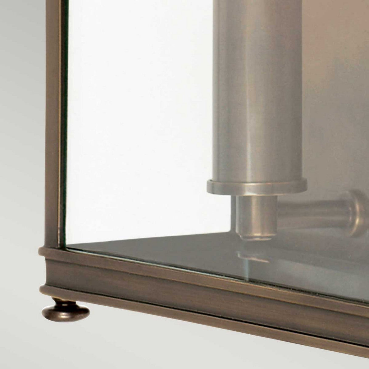 The image showcases the Holborn 2 Light Outdoor Wall Light in dark bronze, highlighting its rectangular glass pane encased in a solid brass frame and featuring cylindrical elements within.