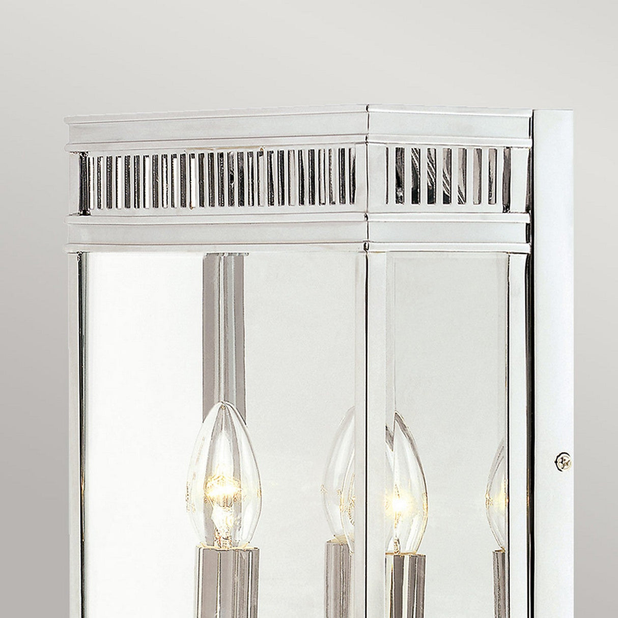 Close-up of the Holborn 2 Light Outdoor Wall Light in polished chrome, featuring two decorative exposed bulbs. The lit bulbs are framed by a rectangular mirrored design with vertical slit details on the upper section, evoking a touch of Georgian style.