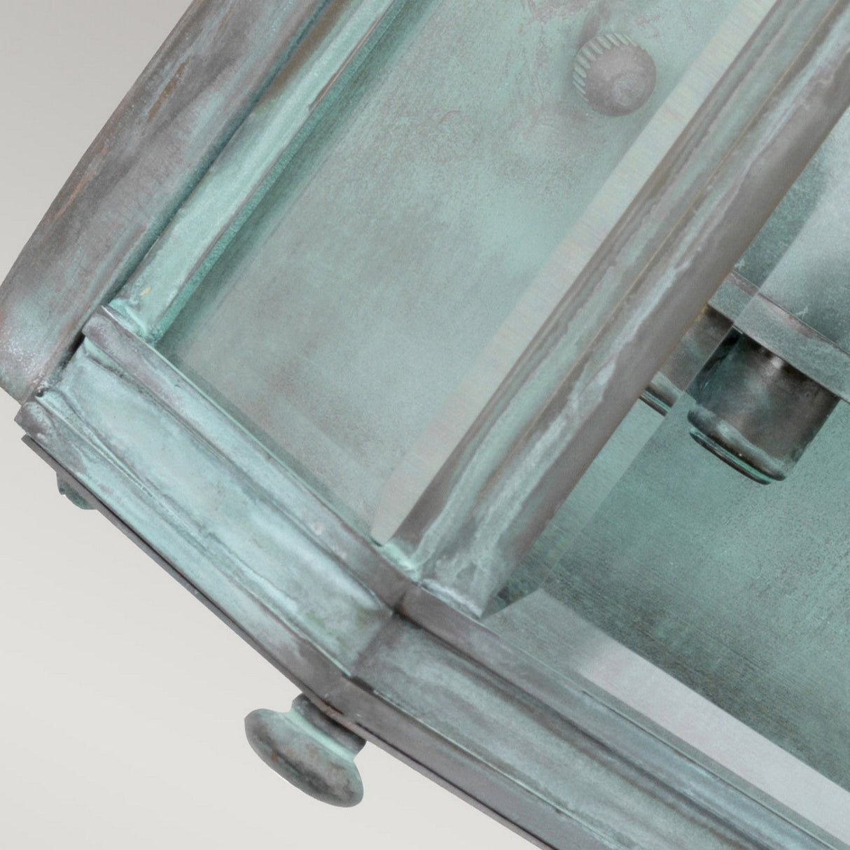 Close-up of the Holborn 2 Light Outdoor Wall Light - Verdigris, crafted with solid brass. This vintage-style lantern displays transparent glass panels and visible screws, highlighting its craftsmanship and aged appearance.