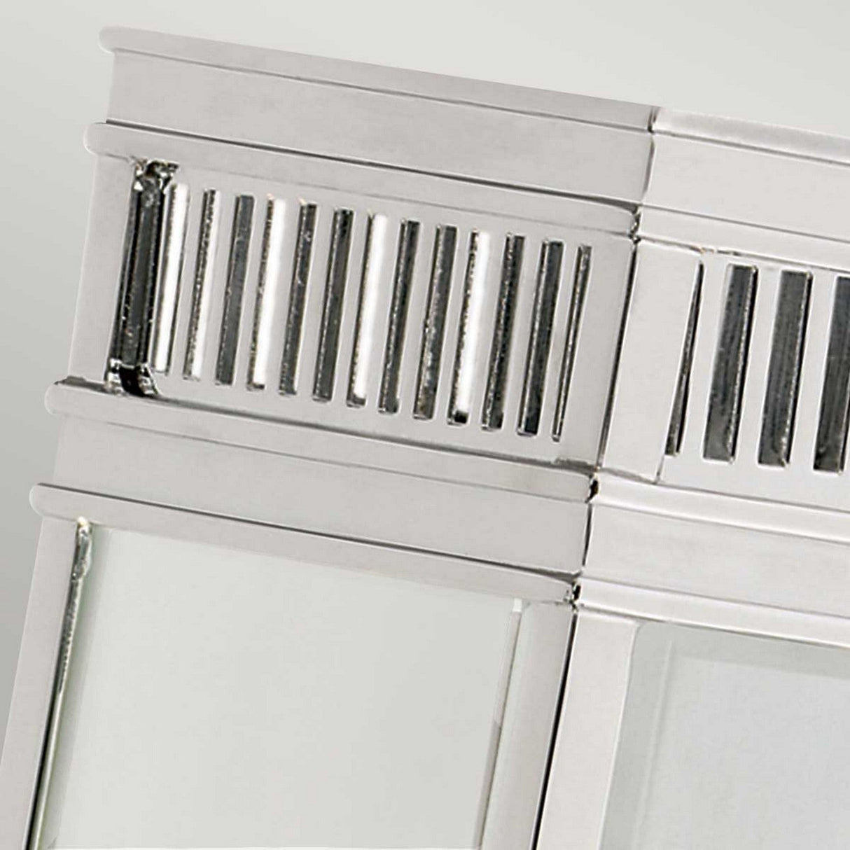 A close-up shot of the Holborn 1 Light Outdoor Small Wall Lantern in polished chrome, showcasing its shiny metallic vent cover with vertical slats against a plain background. The design boasts a sleek, reflective finish and modern aesthetic, echoing an elegant Georgian lantern style.