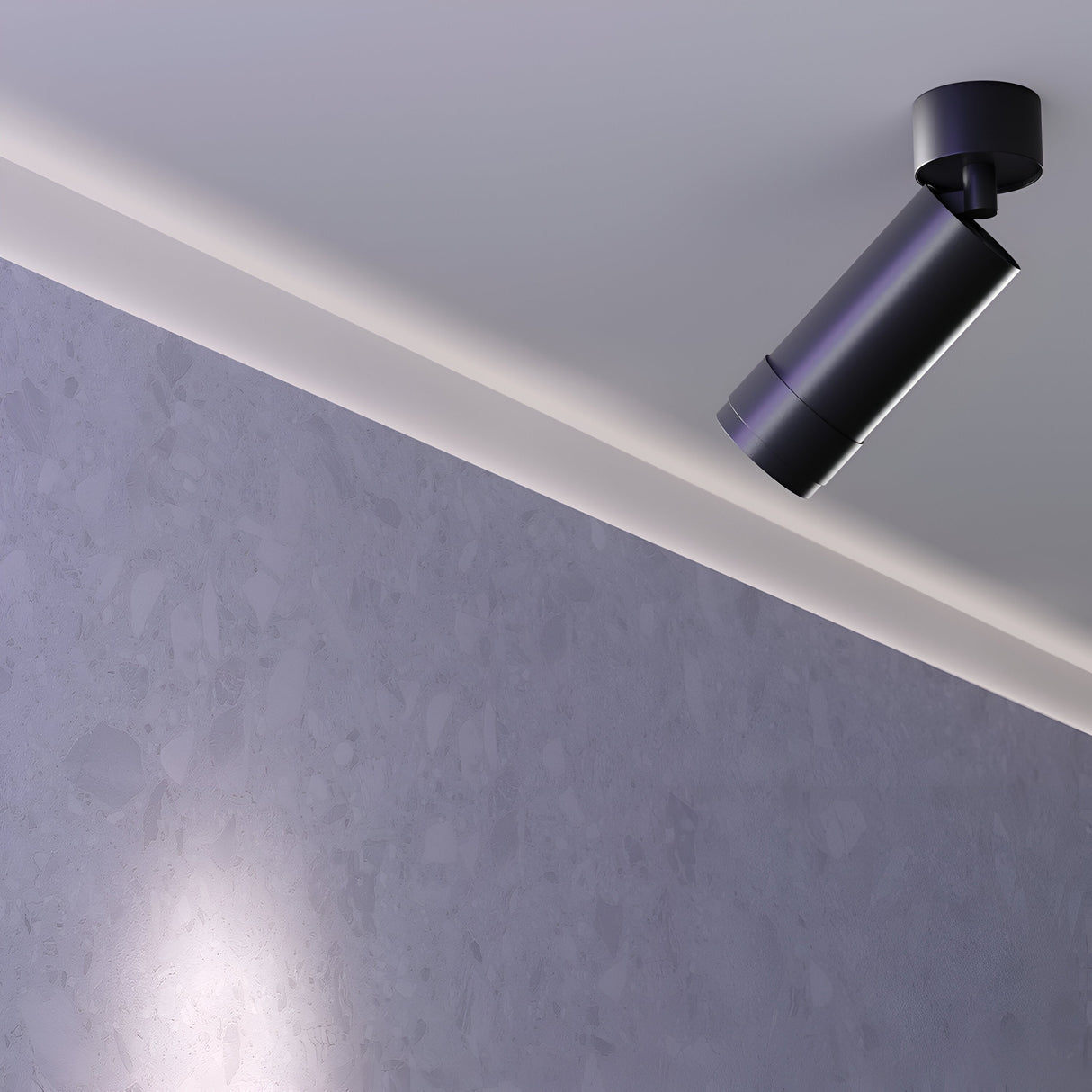 The Focus Zoom LED Single Surface-Mounted Spotlight 12W 3000K in black is mounted on a white ceiling, casting light on a textured gray wall. The industrial design highlights the walls subtle pattern under focused illumination, creating an elegant effect.